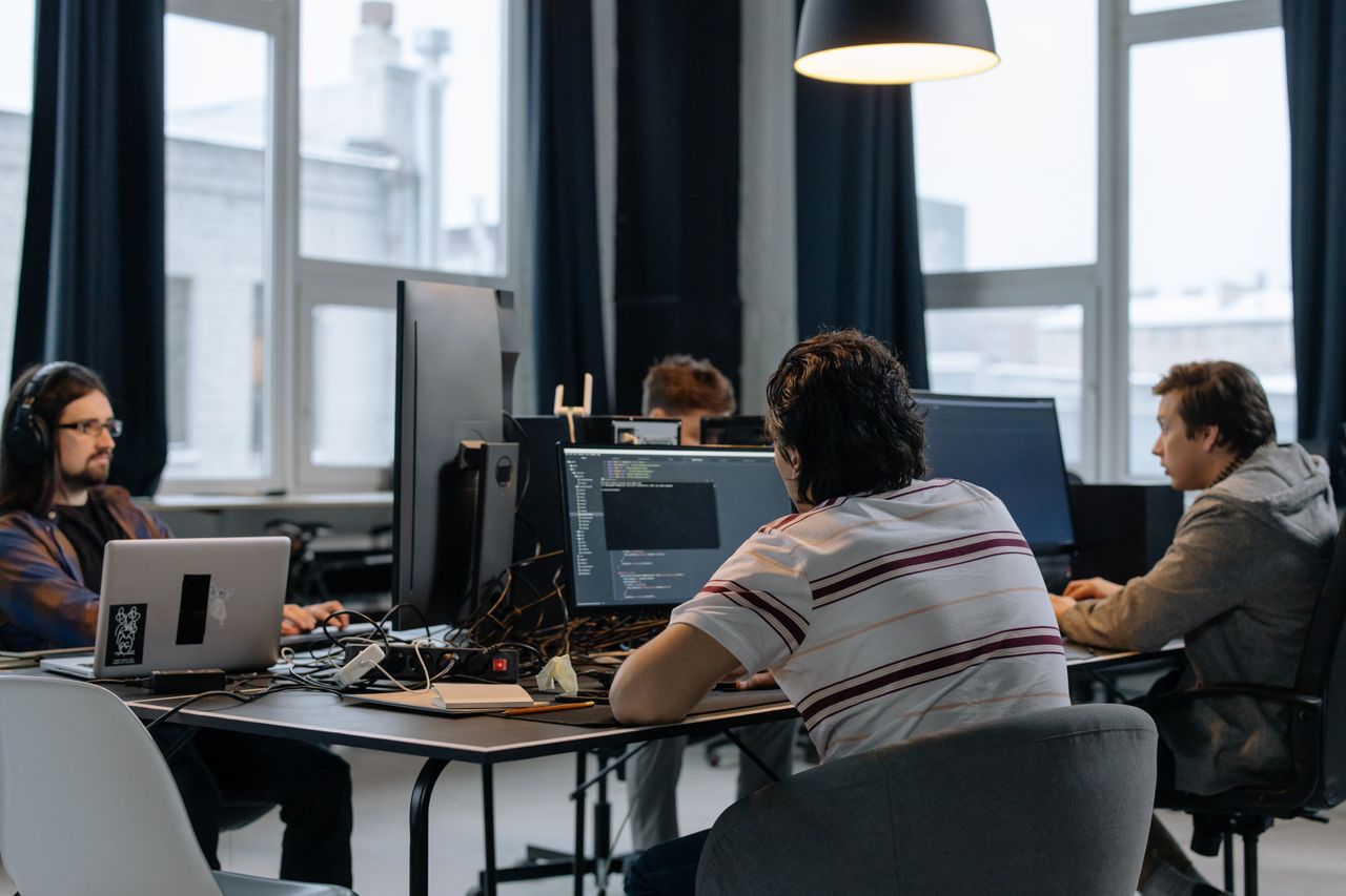 Services Team of developers working together on computers in a modern tech office.