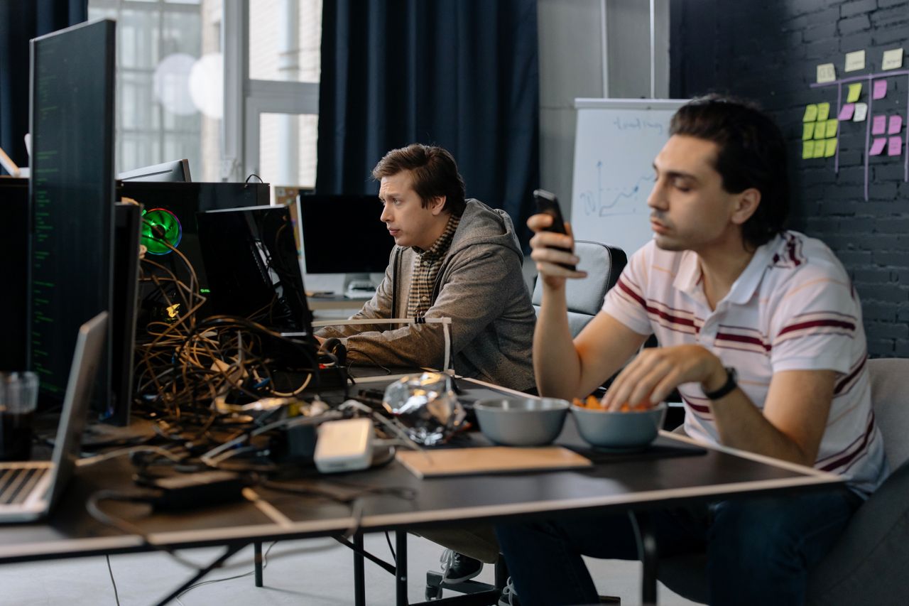 Mastering the First Impression: Your intriguing post title goes here Two men working in a modern office setup, focused on technology and collaboration.
